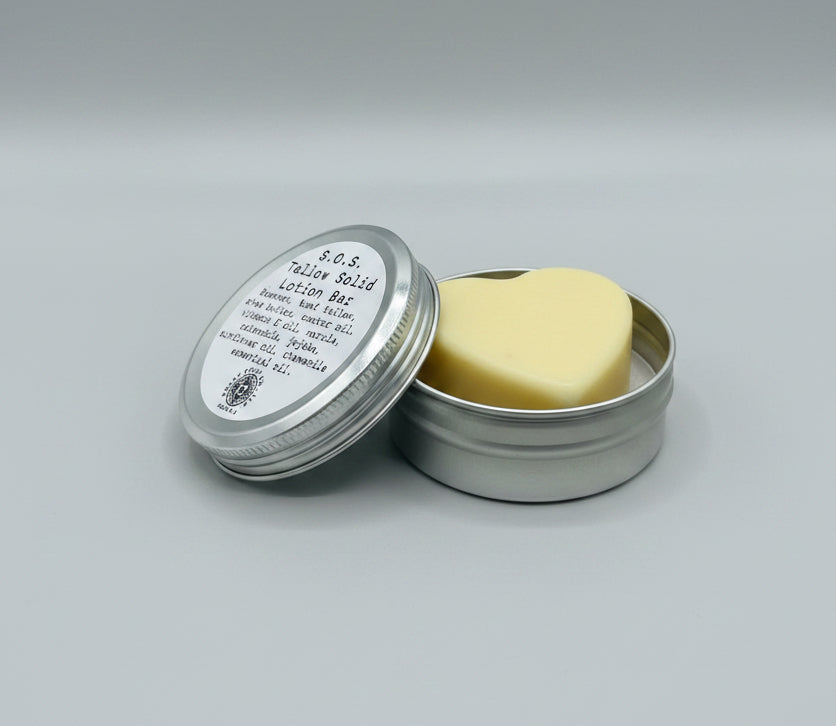 S.O.S. Tallow Solid Lotion Bar in a metal container on a wooden surface with 'RPC Co.' written above.